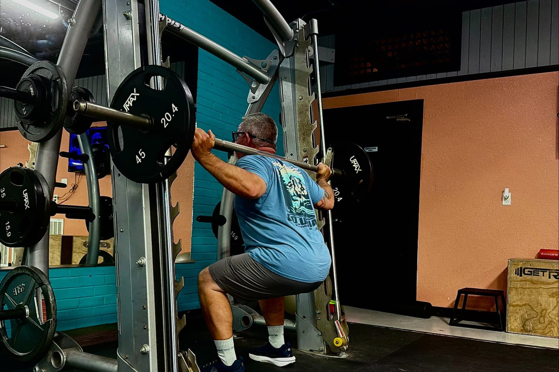 Member training on the squat rack at Absolute Fitness