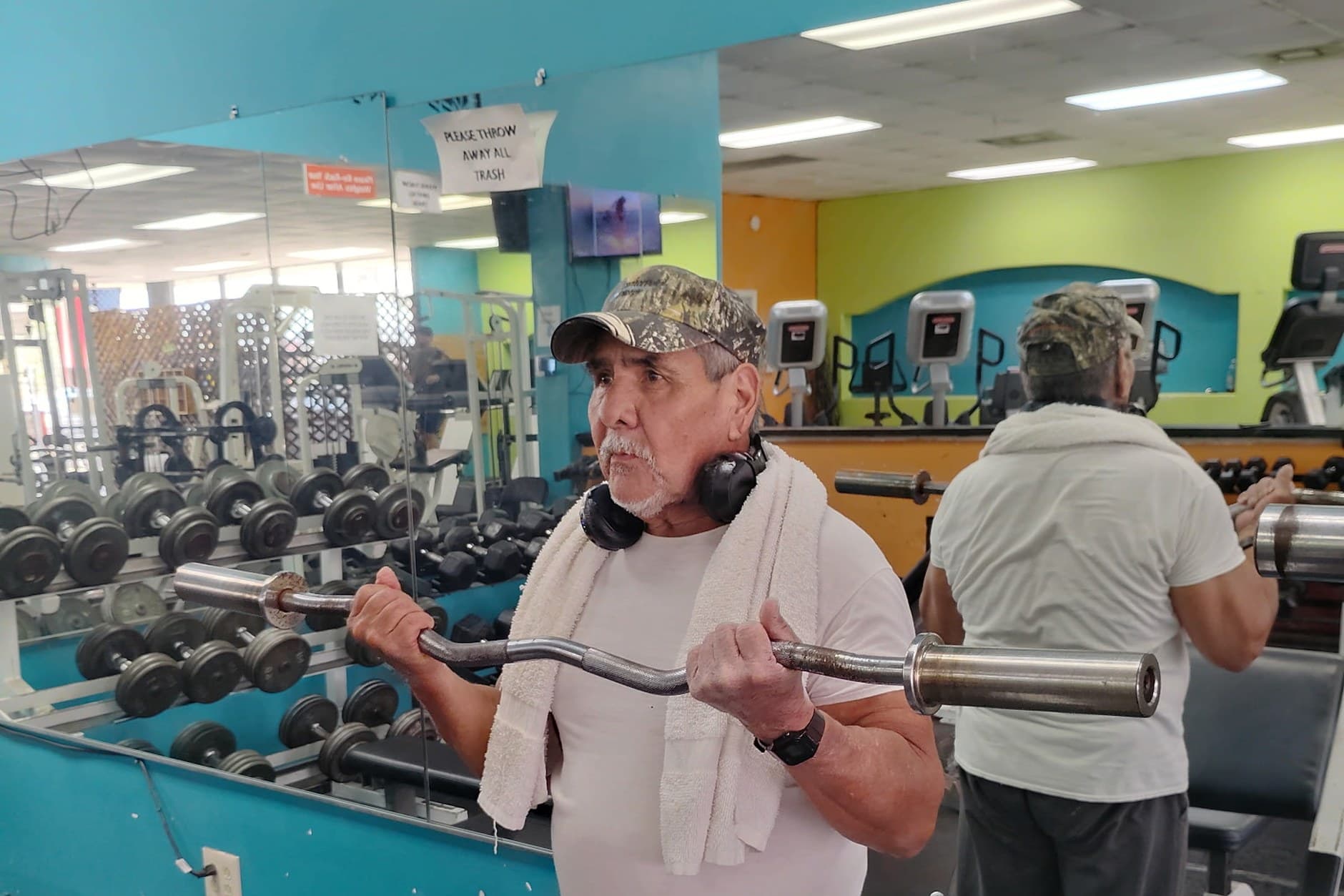 Longtime member doing barbell curls at Absolute Fitness
